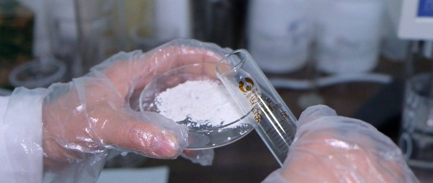 hands using cuvette to test jianjie binder in white powder form